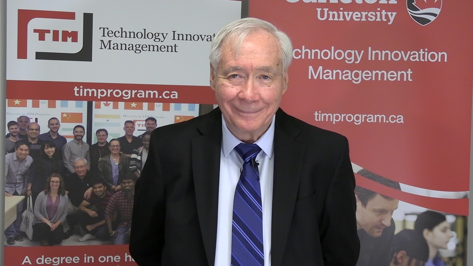 Tony Bailetti smiling in front of TIM Program banners